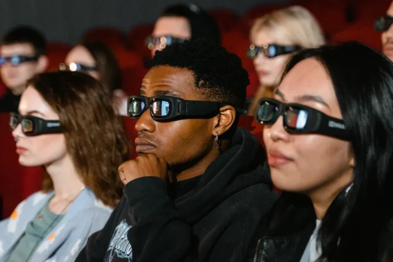 UK cinemas sell out screenings of Holmes documentary You Can See Everything A diverse group of adults wearing 3D glasses are watching a movie in a cinema theater